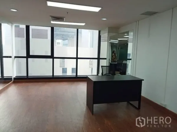 办公空间 出租在Ratchathewi, Bangkok - 转角工位，配大面积窗户、筒灯和单人书桌。
