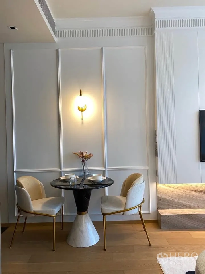 公寓 for rent in Pathum Wan, Bangkok - 紧凑餐区设圆形大理石餐桌、两把软包椅与壁灯。