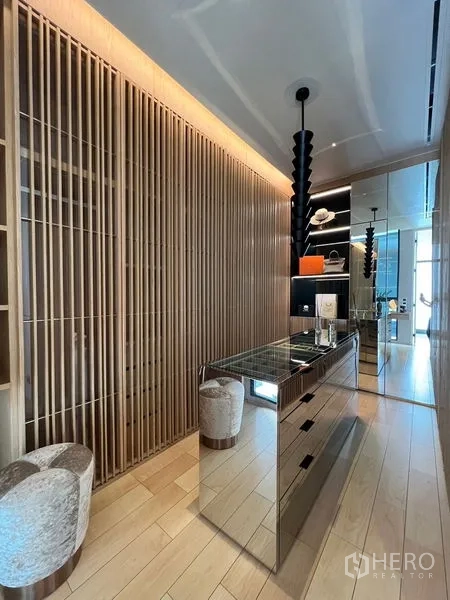 带办公室的家 出售在Prawet, Bangkok - 步入式更衣间，中岛镜面柜、木格栅墙与陈列层架。