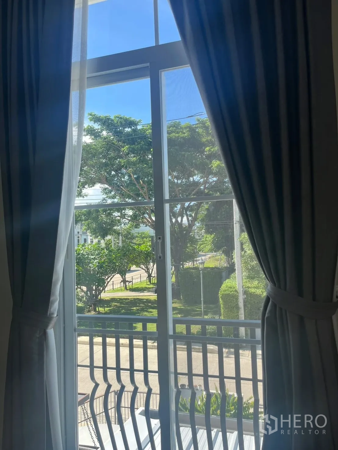 联排别墅 for rent in Prawet, Bangkok - 楼上窗与小阳台眺望绿树的景色。