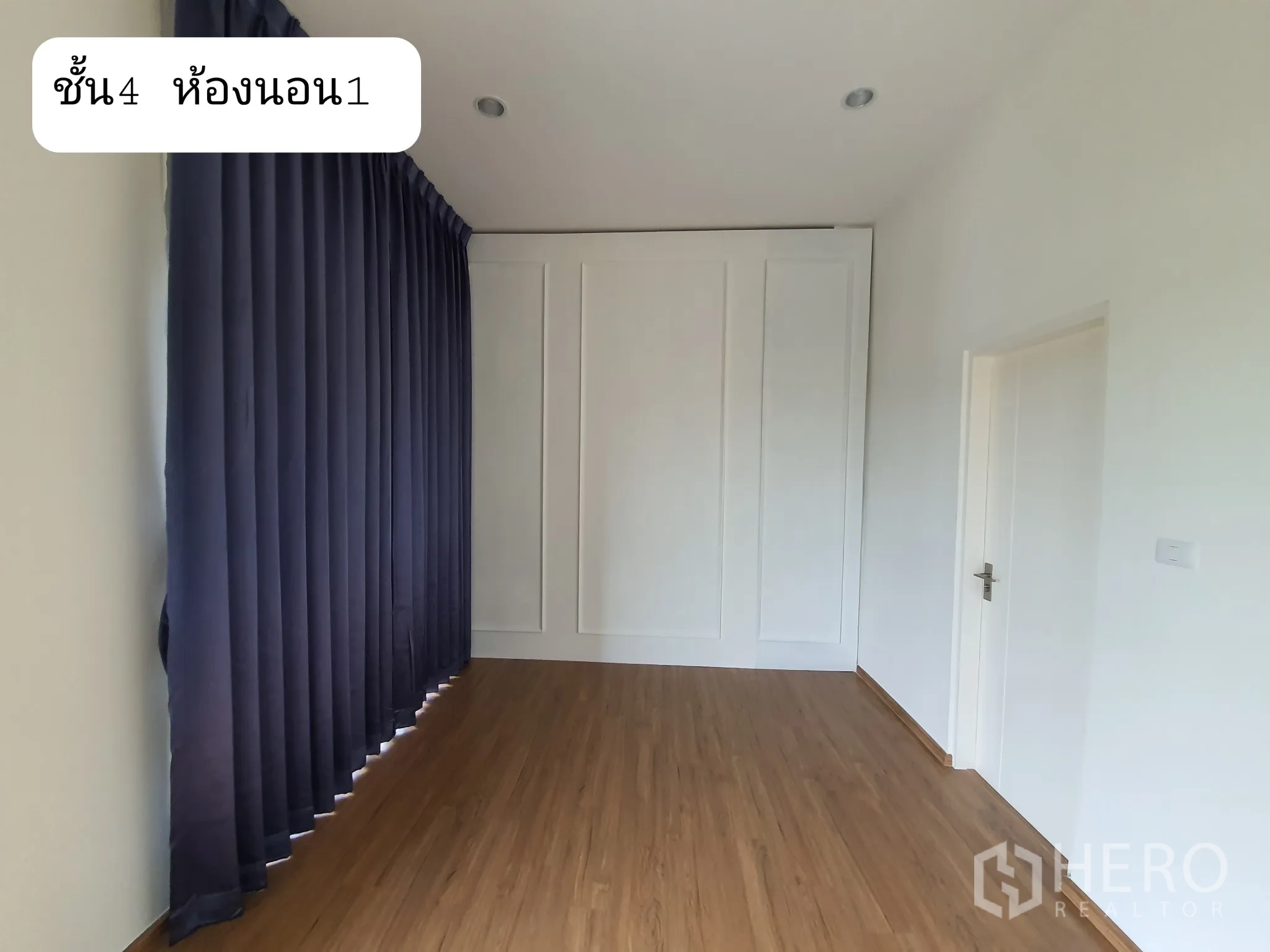 带办公室的家 出租或出售在Prawet, Bangkok - 楼上卧室，整面落地深色窗帘与造型墙，木地板。