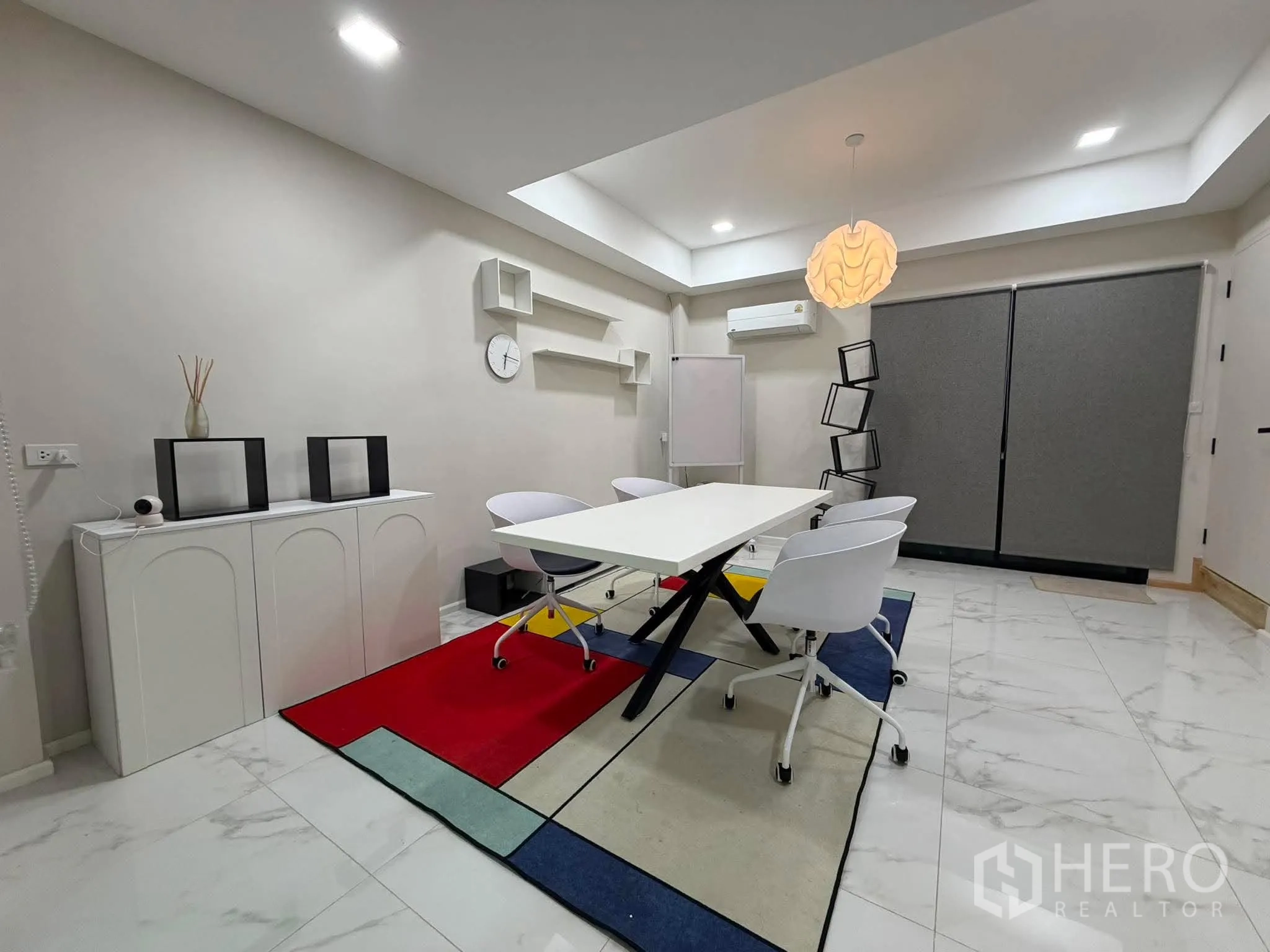 家庭办公室 for rent in Phra Khanong, Bangkok - 明亮会议室，折叠桌、白色椅子和彩色地毯。