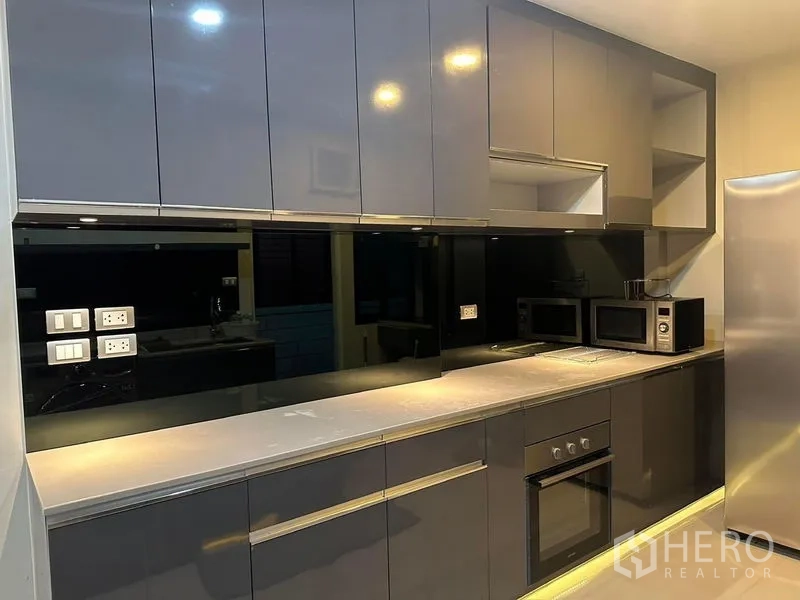 Detached House for rent in Bang Phli, Samut Prakan - Sleek built-in kitchen with black backsplash, oven and multiple microwaves.