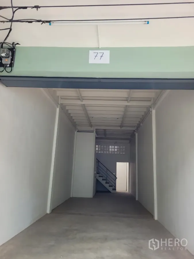 Shophouse for rent in Khlong Toei, Bangkok - Open-front shophouse bay with high ceiling, concrete floor and rear staircase near Thonglor BTS.