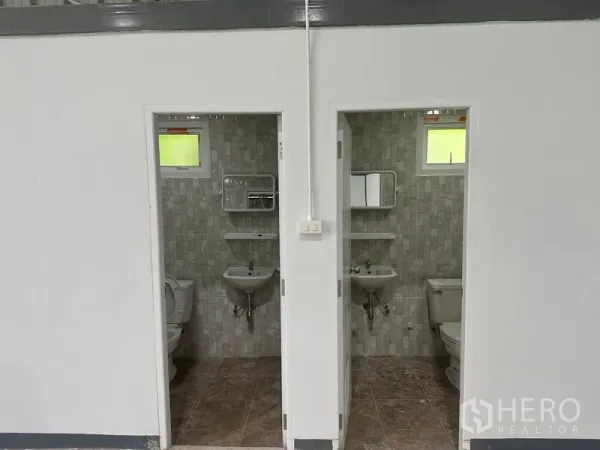 คลังสินค้า ให้เช่าในKhlong Toei, Bangkok - ห้องน้ำปูกระเบื้องสองห้อง พร้อมโถสุขภัณฑ์ อ่างล้างมือ กระจก และหน้าต่าง