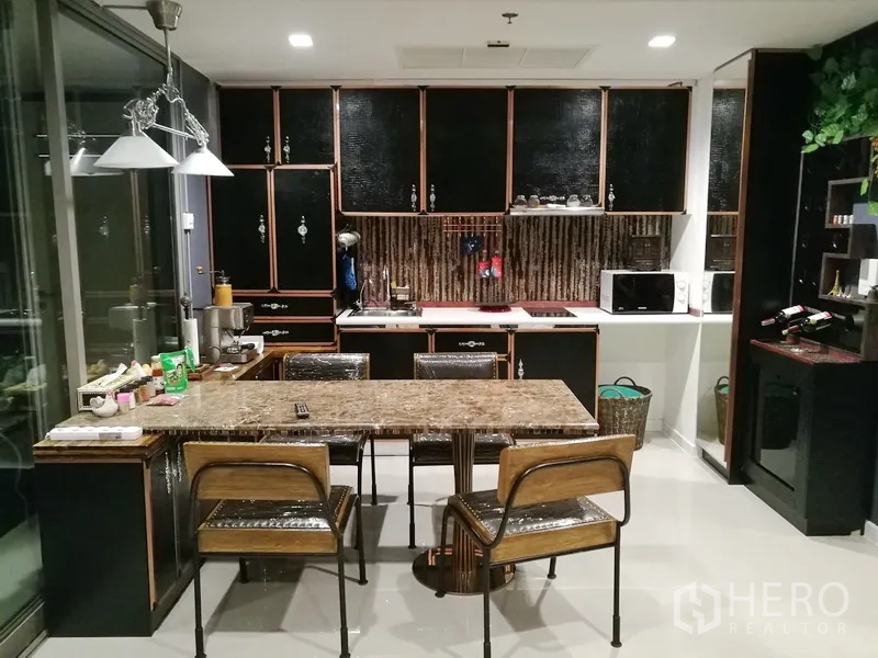 公寓 出租或出售在Bang Kho Laem, Bangkok - 开放式厨房，黑色纹理橱柜、大理石餐岛与吊灯。