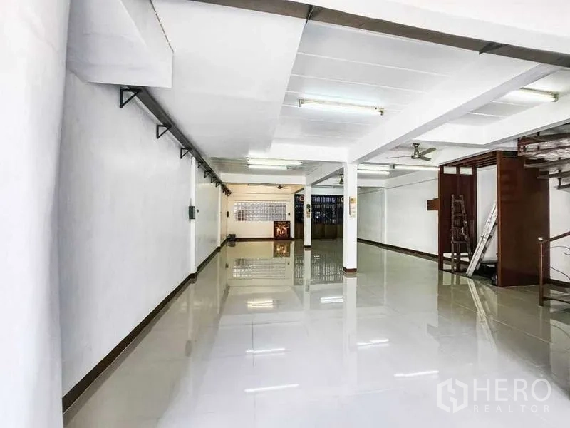 Home Office for rent in Khlong Toei, Bangkok - Deep rectangular hall with central columns, wall brackets and a secure front gate.