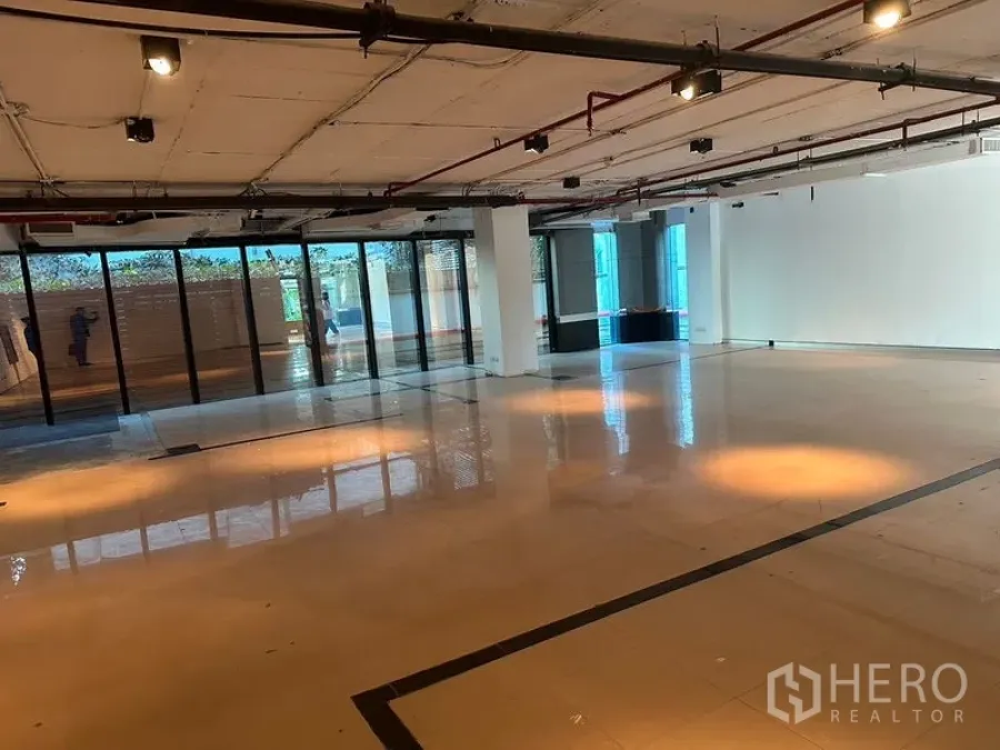 Office Space for rent in Khlong Toei, Bangkok - Spacious workspace with floor-to-ceiling windows, track lighting and glossy tiled floors suitable for flexible layouts.