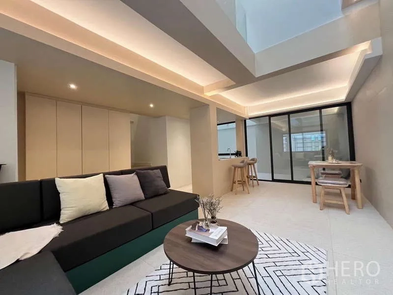 联排别墅 出售在Khlong Toei, Bangkok - 开放式客餐厅与厨房岛台，吊顶氛围灯与推拉门。