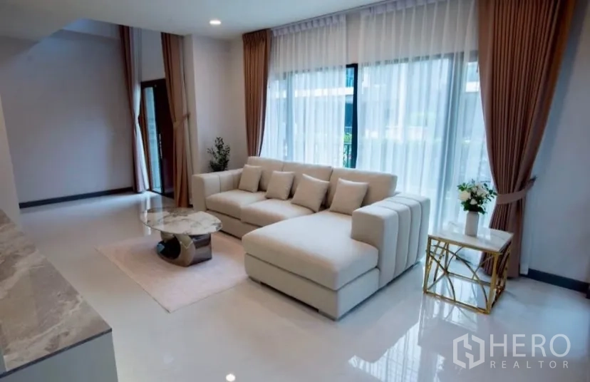 独立式住宅 出租在Bang Phli, Samut Prakan - 阳光充足的会客区，大窗与纱帘、组合沙发。
