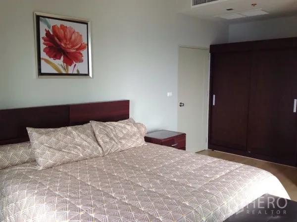 公寓 出租或出售在Watthana, Bangkok - 主卧配大床、床头柜与深色木质衣柜。