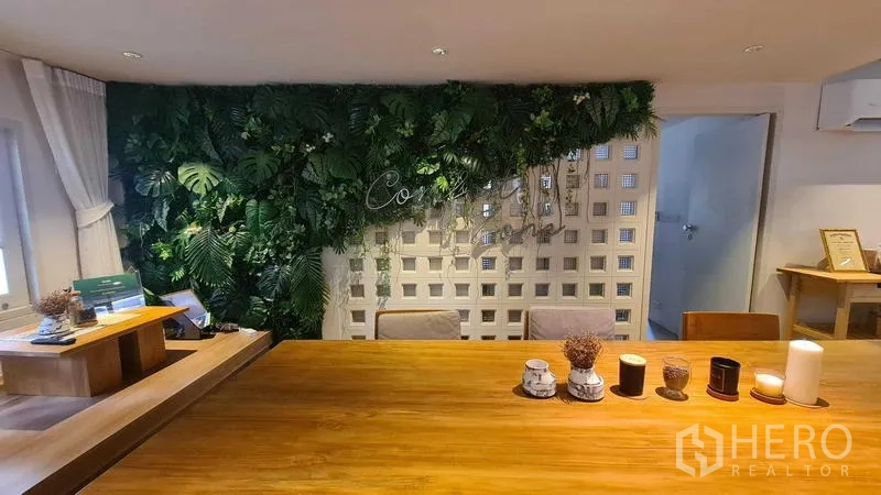 Detached House for rent in Watthana, Bangkok - Feature wall with vertical garden beside a wooden dining table.