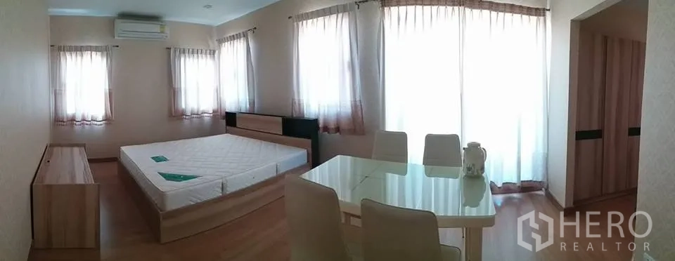 独立式住宅 出租在Pathum Thani - 宽敞主卧，配大床、休闲区与落地窗纱帘