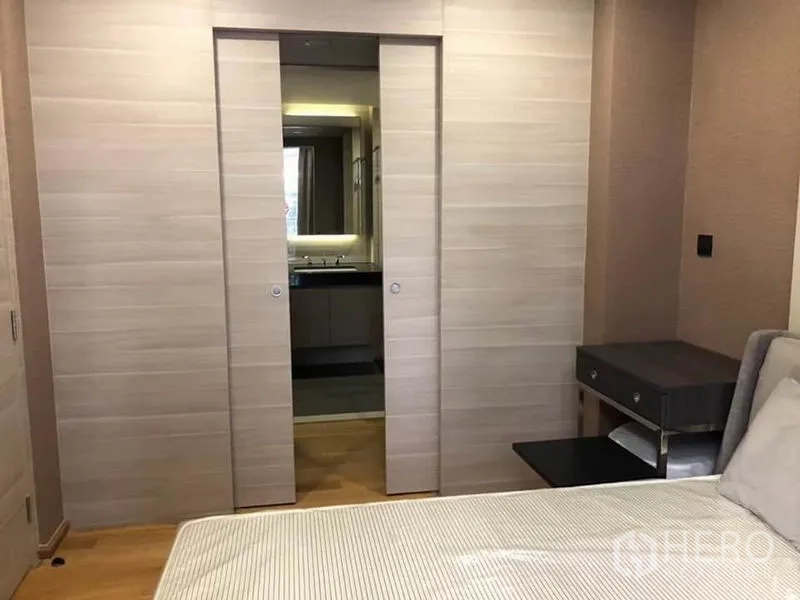 公寓 出租在Pathum Wan, Bangkok - 卧室望向推拉暗门，连接到浴室的洗手台区域。