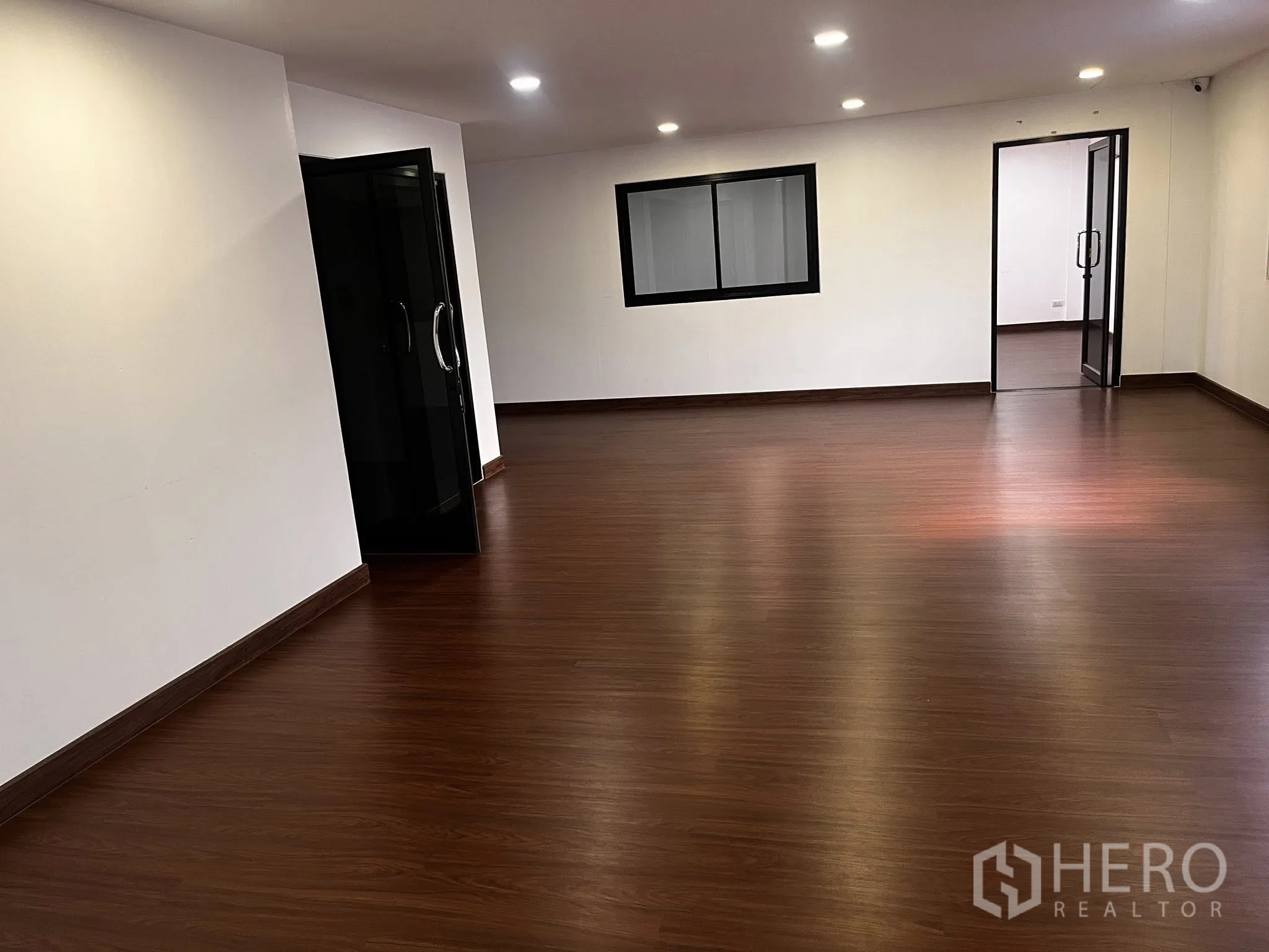 Warehouse for rent in Lat Phrao, Bangkok - Large office space with wood-look flooring and multiple downlights.