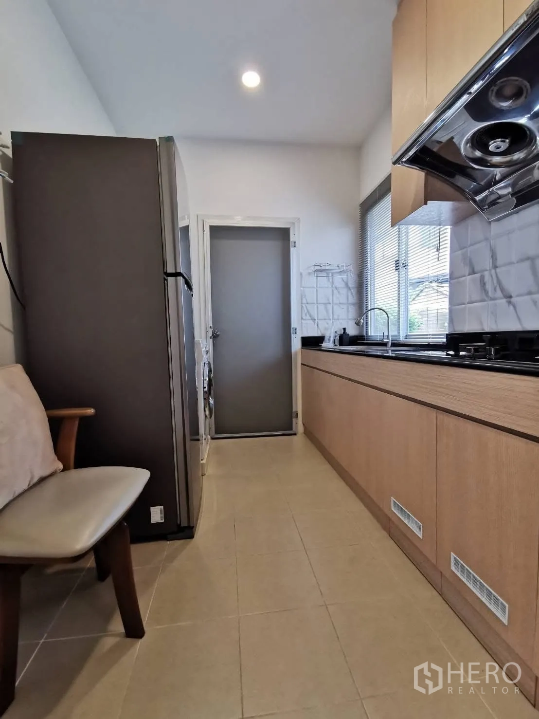 บ้านเดี่ยว for rent in Bang Phli, Samut Prakan - ห้องครัวแบบแกลลี ตู้ไม้ล่าง–บน เคาน์เตอร์สีดำ เครื่องดูดควัน ตู้เย็นและเครื่องซักผ้า