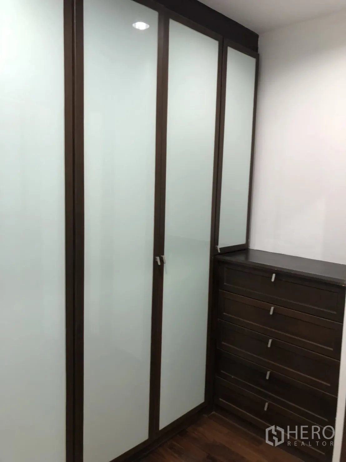 Condominium for rent in Watthana, Bangkok - Walk-in closet with tall frosted doors and drawers.