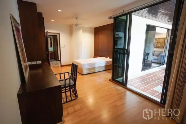 房间 出租在Watthana, Bangkok - 卧室通过推拉门连通有顶露台，木地板并设学习角。