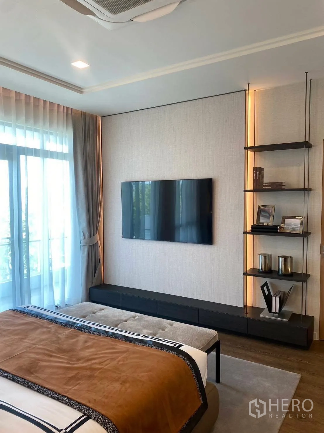 Detached House for rent or sale in Bang Phli, Samut Prakan - Master bedroom wall with mounted TV, floating console, and display shelves.