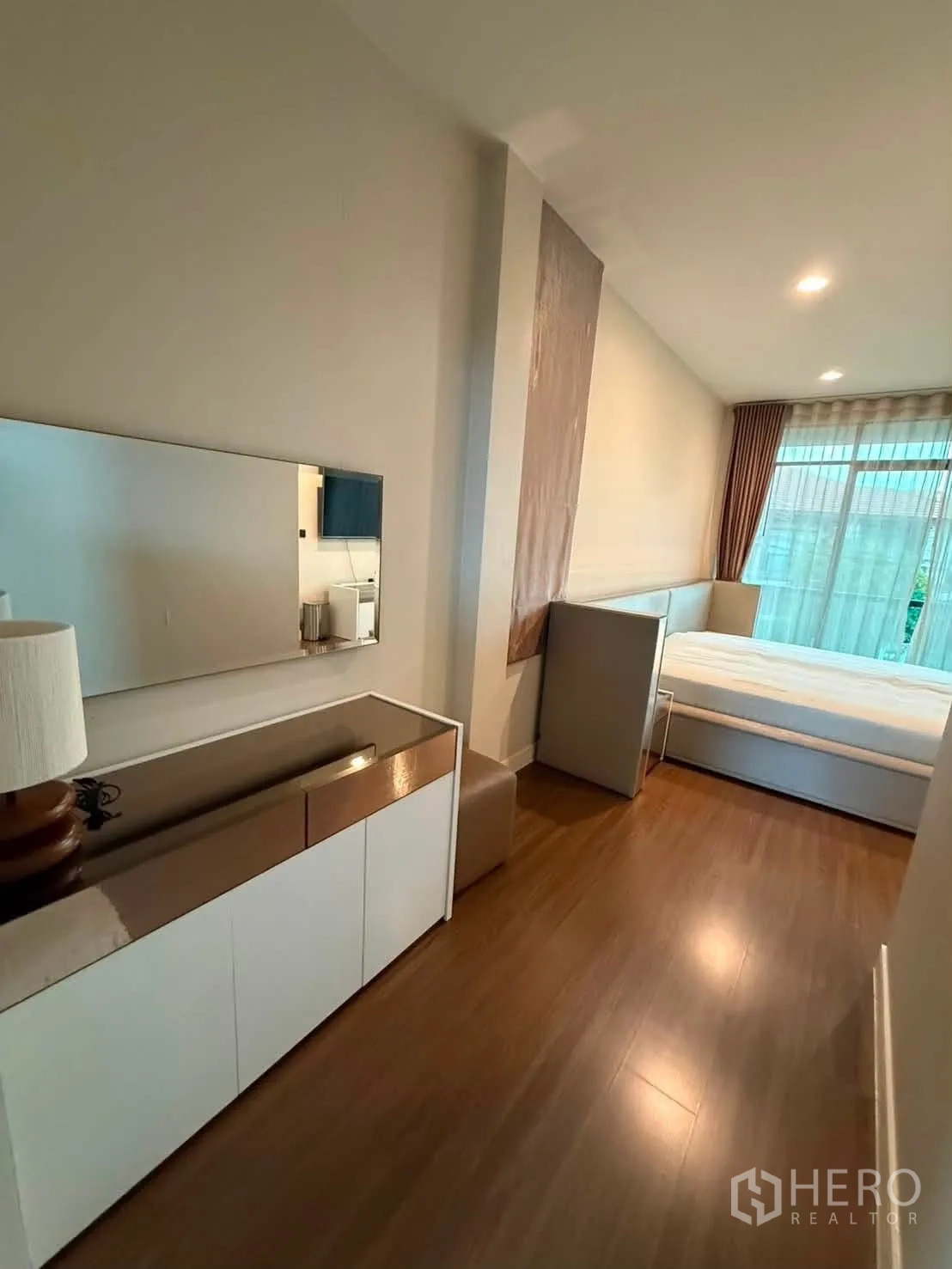 Detached House for rent in Bang Kapi, Bangkok - Bedroom area with console cabinet, wall mirror, and floor-to-ceiling window.