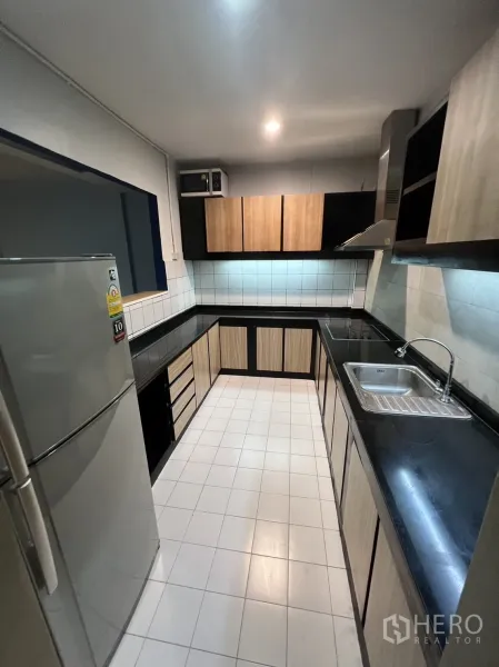 联排别墅 出租在Watthana, Bangkok - 明亮厨房视角，配冰箱、水槽与充裕台面空间。