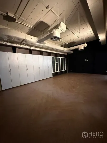 办公空间 出租在Watthana, Bangkok - 独立办公室，木地板、整排白色储物柜与深色墙面。
