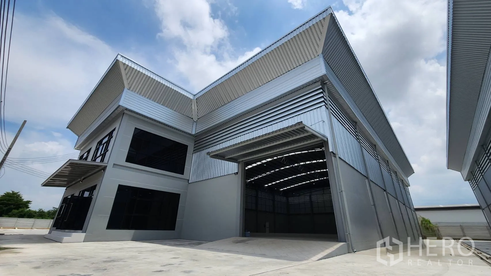 工厂 出租或出售在Bang Bo, Samut Prakan - 邦博北榄府现代厂房外观，高卷闸门与宽阔装卸区，金属包板立面。