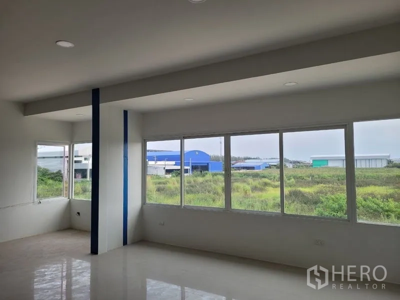 Factory for rent or sale in Khlong Luang, Pathum Thani - Office space with panoramic windows facing neighboring factories and open fields.