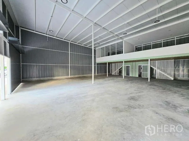 Warehouse for rent in Wang Thonglang, Bangkok - Spacious high-clearance warehouse hall with steel roof trusses and mezzanine offices.