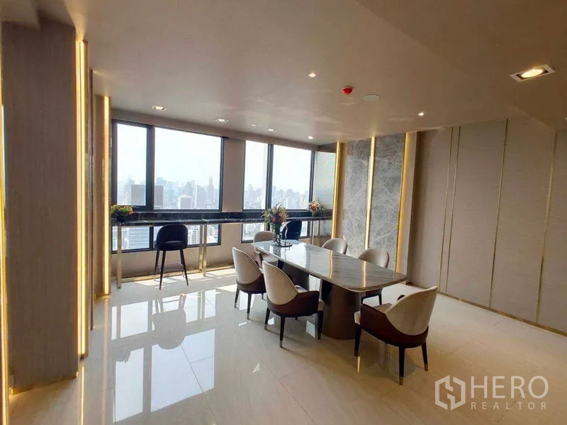 Condominium for rent in Watthana, Bangkok - High-floor residents’ lounge with a long dining table and skyline views.