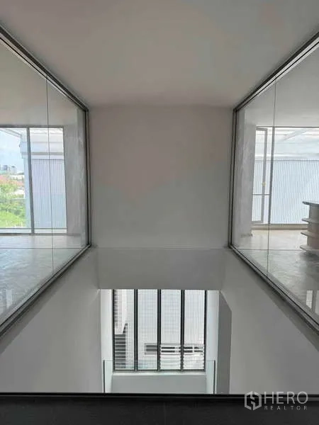 Home Office for rent or sale - Upper bridge corridor overlooking a double-height atrium with glass partitions on both sides.