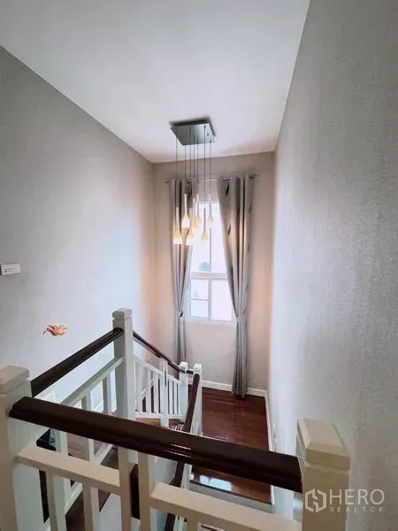 บ้าน ให้เช่าในPrawet, Bangkok - โถงบันได ราวไม้ โคมไฟห้อย และหน้าต่างมีผ้าม่าน