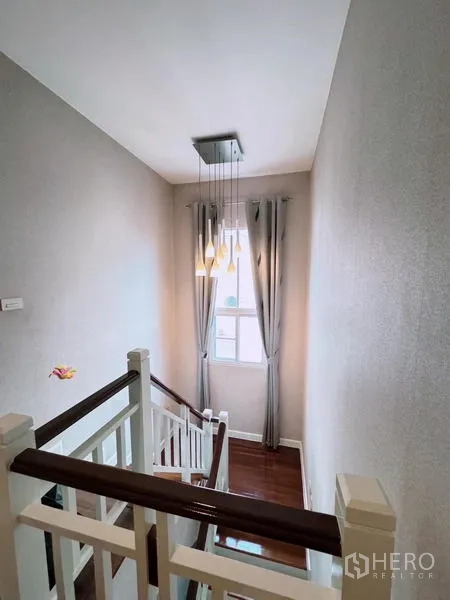 บ้าน ให้เช่าในPrawet, Bangkok - โถงบันได ราวไม้ โคมไฟห้อย และหน้าต่างมีผ้าม่าน