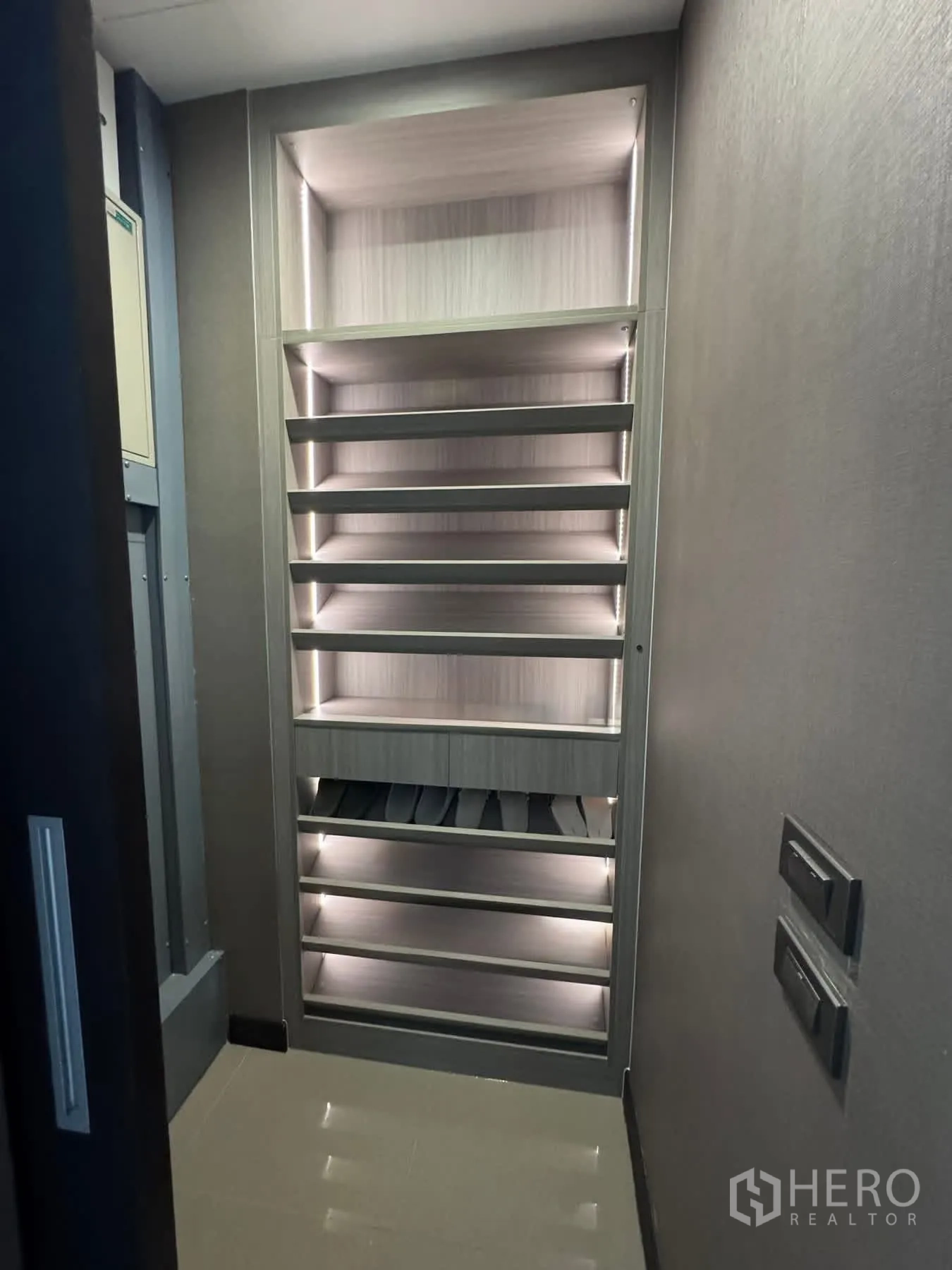 Townhouse for rent or sale in Lat Phrao, Bangkok - Built-in illuminated shoe cabinet with pull-out racks.