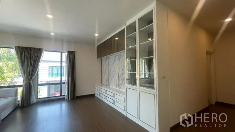 Detached House for rent or sale in Prawet, Bangkok - Upstairs family room with wall-to-wall storage cabinets and wide windows.