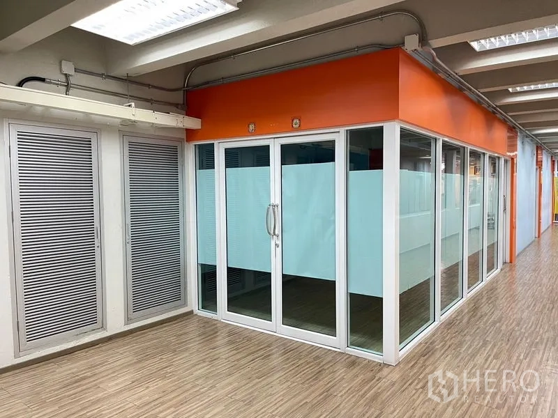 Office Space for rent in Ratchathewi, Bangkok - Glass-fronted office suite with frosted panels and double doors beside a wood-look corridor.