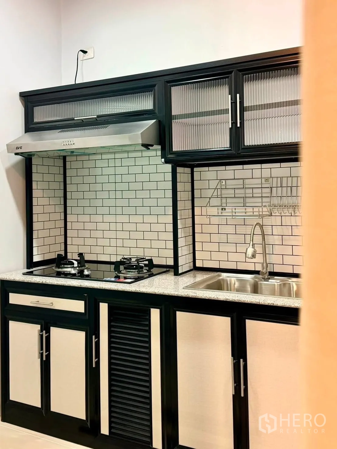 ทาวน์เฮาส์ for rent in Bang Phli, Samut Prakan - ครัวสมัยใหม่พร้อมเตาแก๊ส ฮูดสแตนเลส ผนังกระเบื้องลายอิฐ และอ่างล้างจาน.
