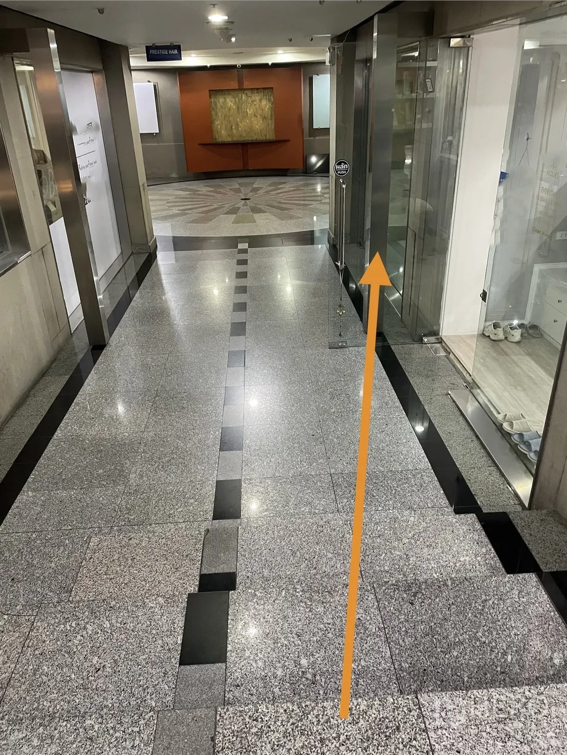 พื้นที่ขายของ for rent in Watthana, Bangkok - โถงทางเดินอาคารพื้นหินแกรนิตเงา มีหน้าร้านสองฝั่งและไฟเพดาน