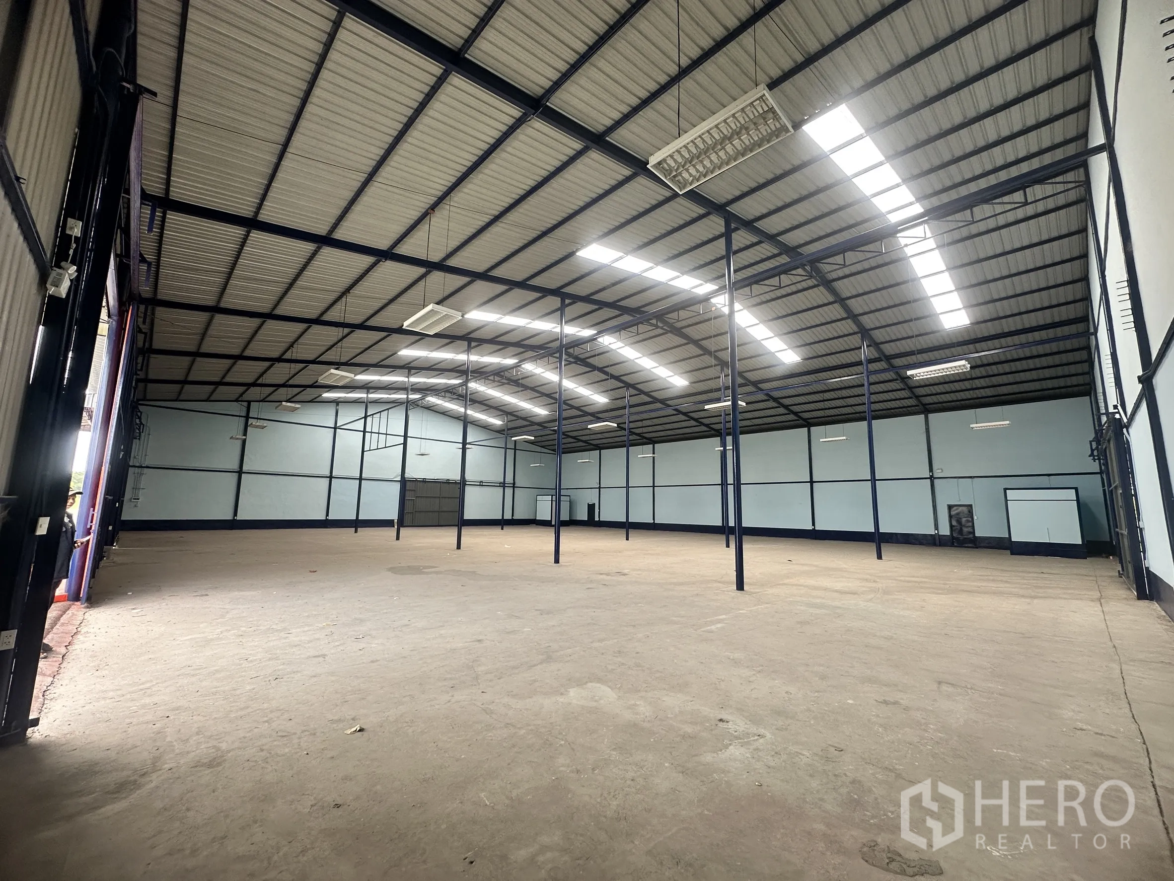 โกดัง for rent in Lat Krabang, Bangkok - มุมมองภายในไปยังช่องโหลดสินค้าที่เปิดโล่งพร้อมประตูม้วนสูงและพื้นคอนกรีต