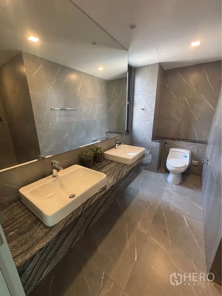 家庭办公室 for rent or sale in Suan Luang, Bangkok - 浴室配双台盆石材台面与坐便器。
