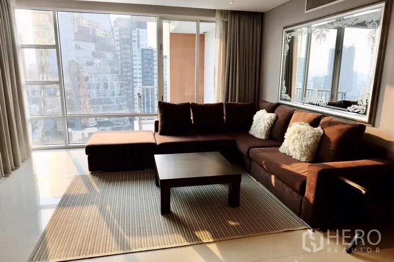 คอนโด ให้เช่าในWatthana, Bangkok - ห้องนั่งเล่นสว่าง โซฟาเข้ามุมสีน้ำตาล โต๊ะกลาง และหน้าต่างสูงจรดเพดานวิวเมือง
