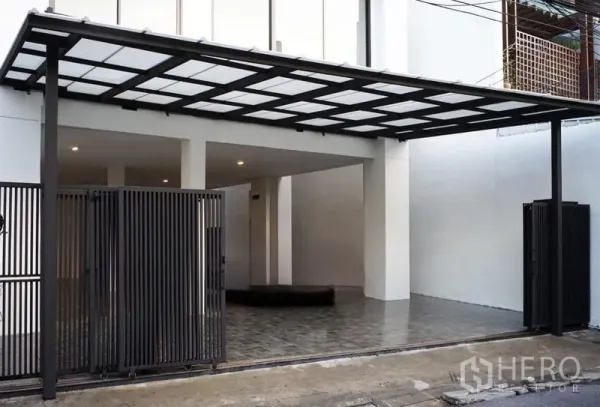 สำนักงานที่บ้าน ให้เช่าหรือขายในWatthana, Bangkok - ที่จอดรถมีหลังคา พร้อมประตูเหล็กสีดำและพื้นกระเบื้อง