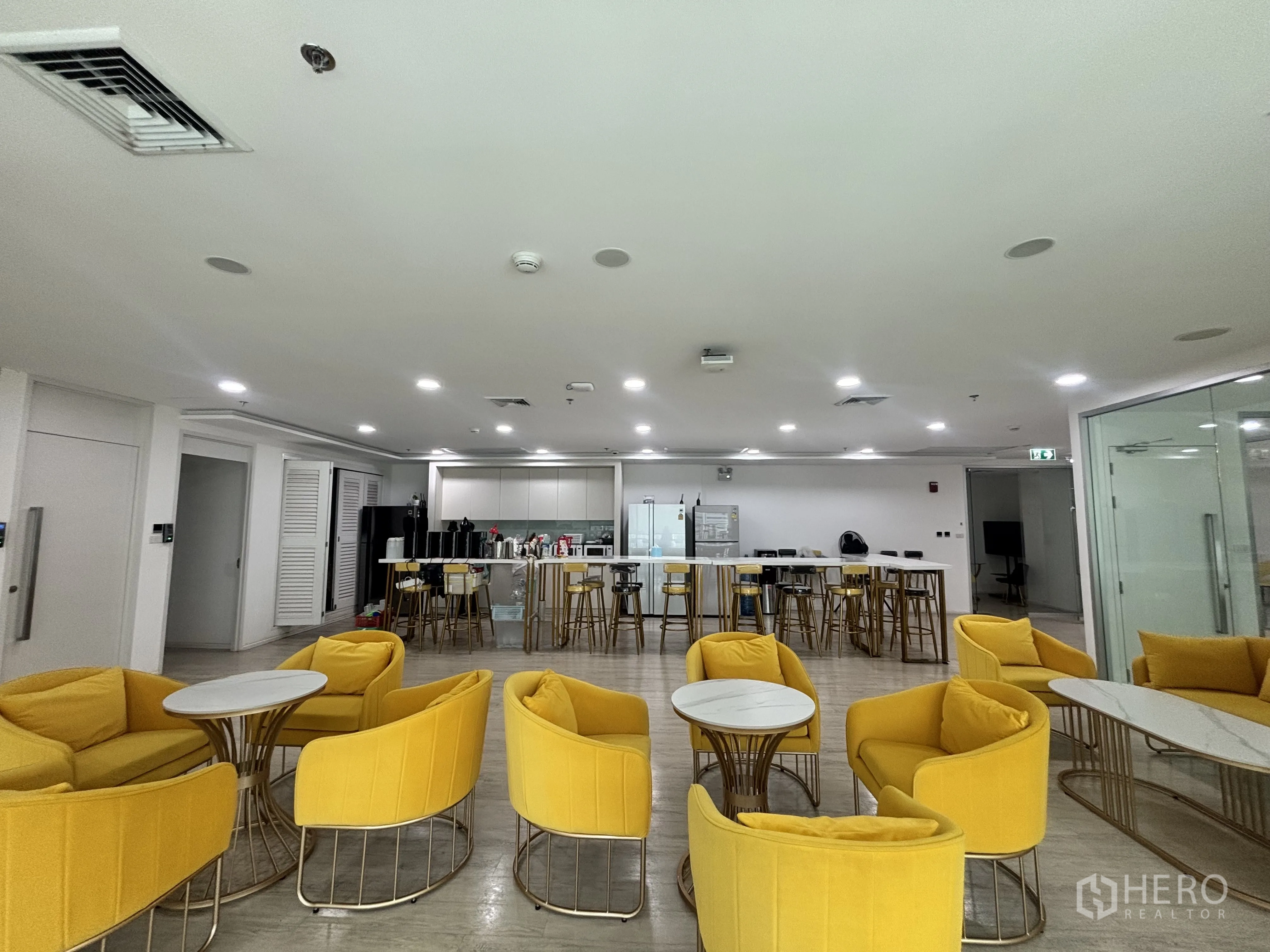 Office Space for rent in Din Daeng, Bangkok - Large pantry and breakout zone with yellow seating and a central kitchen island.