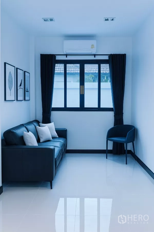Detached House for rent in Wang Thonglang, Bangkok - Cozy sitting area with black sofa, accent chair, and curtained window.