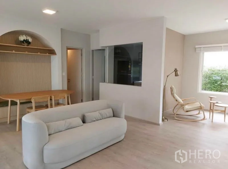 独立式住宅 出租在Prawet, Bangkok - 开放式客餐厅，浅木地板，沙发与餐桌，大面积采光窗。