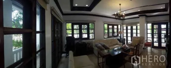 独立式住宅 出租在Bang Phli, Samut Prakan - 全景客厅，木框大窗带来自然光线。