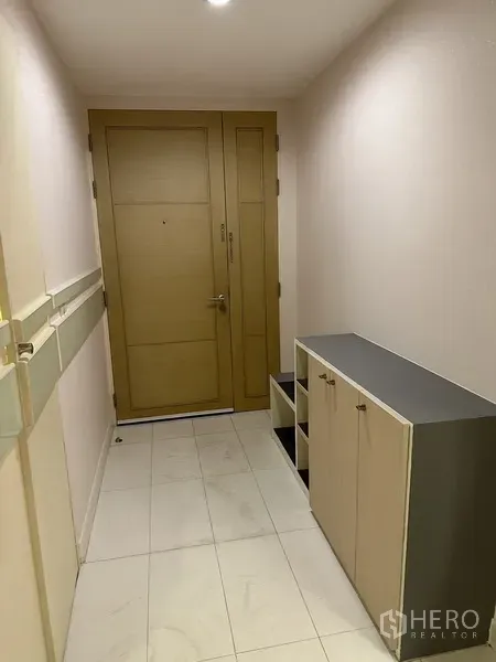 公寓 出租在Watthana, Bangkok - 入户走廊，木门、鞋柜与浅色地砖。