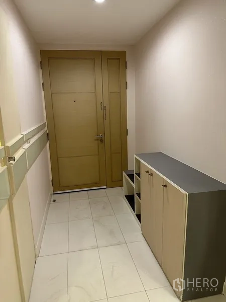 公寓 出租在Watthana, Bangkok - 入户走廊，木门、鞋柜与浅色地砖。