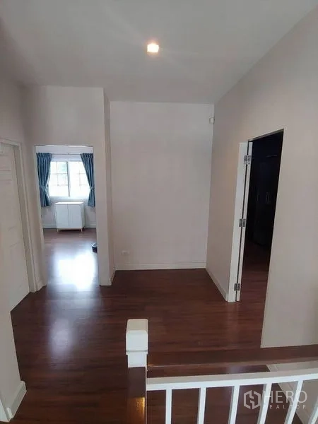 独立式住宅 出售在Khlong Sam Wa, Bangkok - 二层过道，木地板，通向多间卧室的门。