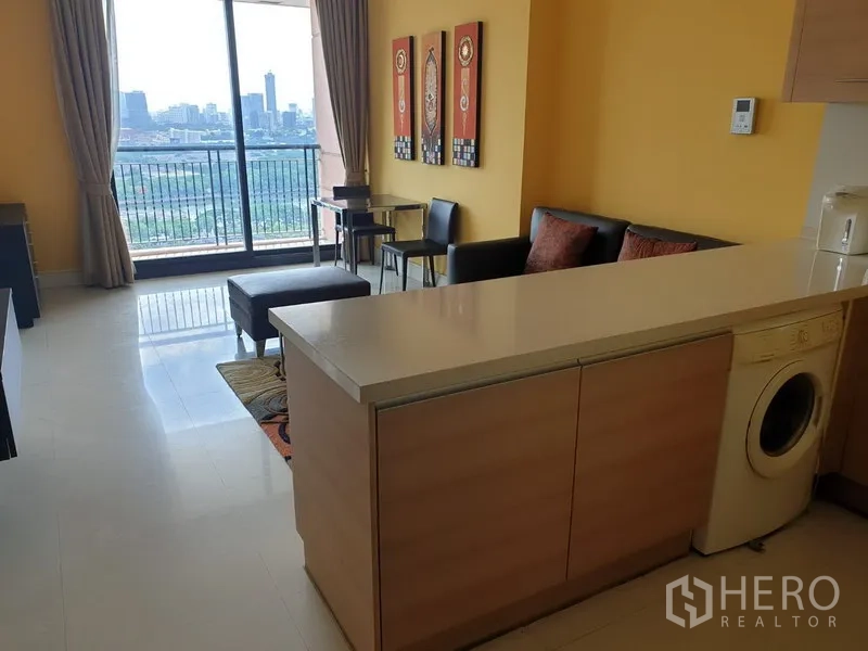 公寓 出租或出售在Khlong Toei, Bangkok - 采光充足的客厅，设长吧台与洗衣机，落地门通往阳台并可眺望城市天际线。